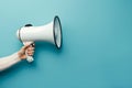 Hand holding megaphone isolated on blue background Royalty Free Stock Photo