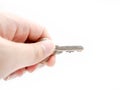 Hand holding a metal door key isolated on background Royalty Free Stock Photo