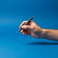 Fingers wrapped around the pen in a writing grip, indicating a Royalty Free Stock Photo