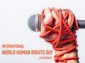 Hand holding microphone and have roped on fist hand with 10 december international HUMAN RIGHTS DAY text Royalty Free Stock Photo
