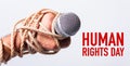 Hand holding microphone and have roped on fist hand with HUMAN RIGHTS DAY text Royalty Free Stock Photo
