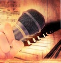 Hand holding microphone and piano Royalty Free Stock Photo