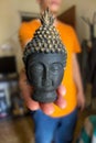 Hand holding miniature lord Buddha statue Royalty Free Stock Photo
