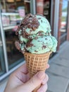 a hand holding an Mint Choco ice cream cone - ai. Royalty Free Stock Photo