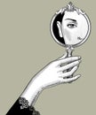 Hand holding a mirror with an eye reflection