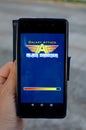 Hand holding mobile with Galaxy Attack Alien shooter game mobile app on the display with blurred background,