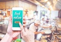Hand holding mobile with Order food online with blur restaurant Royalty Free Stock Photo
