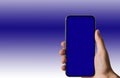 Hand holding mobile phone with blank blue screen in blue and white background Royalty Free Stock Photo