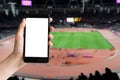 Hand holding mobile phone with blank screen sports stadium Royalty Free Stock Photo