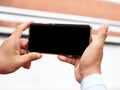 Hand holding mobile phone with empty black screen, searching information, connection with people, study online Royalty Free Stock Photo