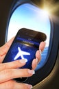 Hand holding mobile phone with flight mode in the airplane Royalty Free Stock Photo