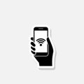 Hand holding mobile phone with free wifi sticker icon Royalty Free Stock Photo