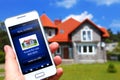 Hand holding mobile phone with house sale offer