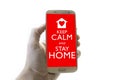 Hand holding mobile phone with keep calm and stay home notification on screen