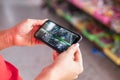 Hand holding mobile phone, watching video, checking CCTV cameras in the shop.