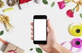 Hand holding mobile smart phone, blank white vertical screen on white background with Christmas and Valentines decoration Royalty Free Stock Photo