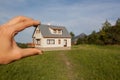 Hand holding a model house in green hill Royalty Free Stock Photo