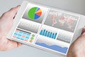 Hand holding modern tablet or mobile device with analytics dashboard