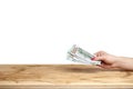 Hand holding money on a wooden table Royalty Free Stock Photo