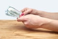 Hand holding money on a wooden table Royalty Free Stock Photo