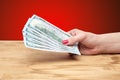 Hand holding money on a wooden table Royalty Free Stock Photo