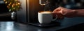 Hand holding a mug of coffee, making coffee at home using modern coffee machine in home interior. A coffee machine Royalty Free Stock Photo