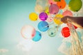 Hand holding multi colored balloons