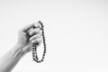 Hand holding a muslim rosary beads or Tasbih on black and white.