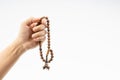 Hand holding a muslim rosary beads or Tasbih on white background.