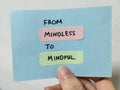 Hand holding a note showing the words From Mindless To Mindful Royalty Free Stock Photo