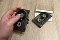 Hand holding an old audio cassette. Tangled tape. Retro medium for recording and playing music. Royalty Free Stock Photo