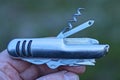 hand holding one gray metallic open folding knife multitool