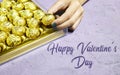 hand holding one piece of golden premium chocolate sweets box isolated