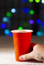 Hand holding a one use cup with lights on the background Royalty Free Stock Photo