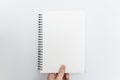 Hand holding opened blinder notebook, blank empty pages, on white background Royalty Free Stock Photo