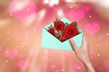 Hand holding opened the blue envelope with red rose flowers Royalty Free Stock Photo