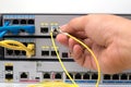 hand holding optic fiber cables with connectors pluging in POE