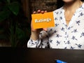 Hand holding orange business card with phrase Ratings