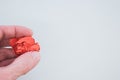 Hand holding an orange crumpled paper ball on a light green background Royalty Free Stock Photo