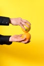 hand holding a orange frut on yellow background Royalty Free Stock Photo