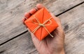 Hand Holding Orange Gift Box and Yellow Ribbon Royalty Free Stock Photo