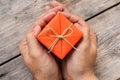 Hand Holding Orange Gift Box and Yellow Ribbon Royalty Free Stock Photo