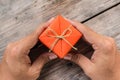 Hand Holding Orange Gift Box and Yellow Ribbon Royalty Free Stock Photo