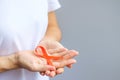 Hand holding Orange Ribbon for Leukemia, Kidney cancer day, world Multiple Sclerosis, CRPS, Self Injury Awareness month. Royalty Free Stock Photo