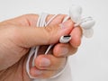 Hand holding a pair of USB-C earphones against a white background