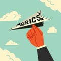 A hand holding a paper airplane brics money