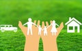 Hand Holding paper family in nature background with car and house. family insurance and protection concept Royalty Free Stock Photo