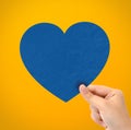 Hand holding paper heart on yellow background Royalty Free Stock Photo