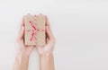Hand holding parcel post gift box, on white background with copy space