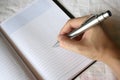 Hand holding pen writing on note book Royalty Free Stock Photo